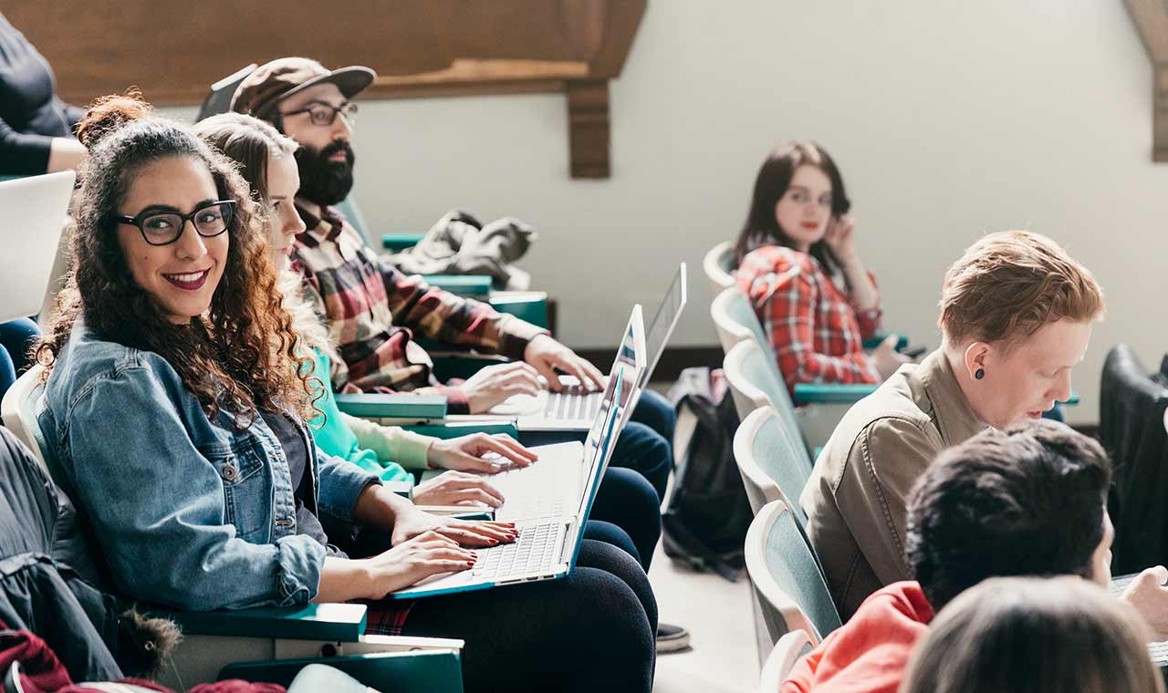 Student in a lecture hall smiling