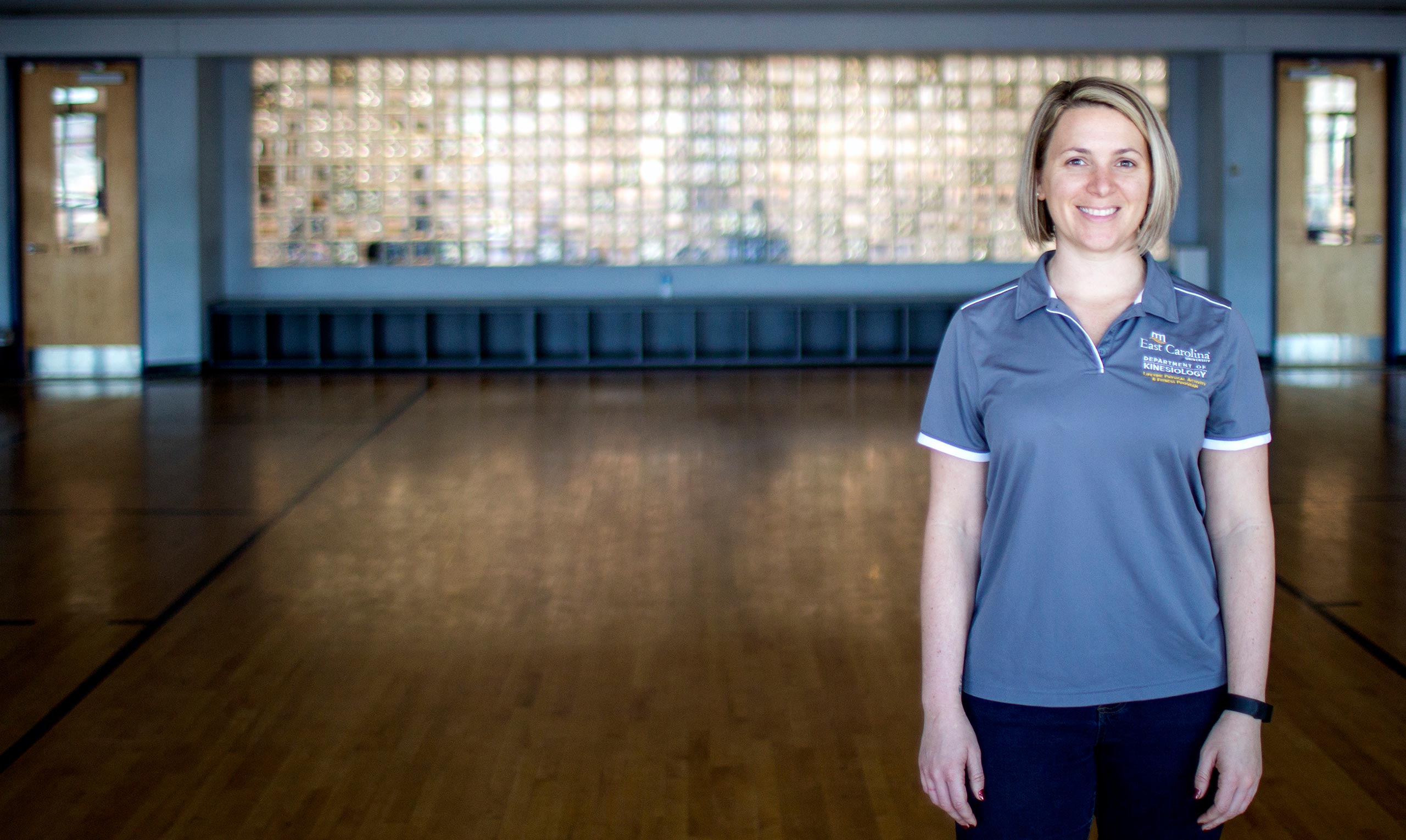 Sue-L Cohen standing in a an open gym
