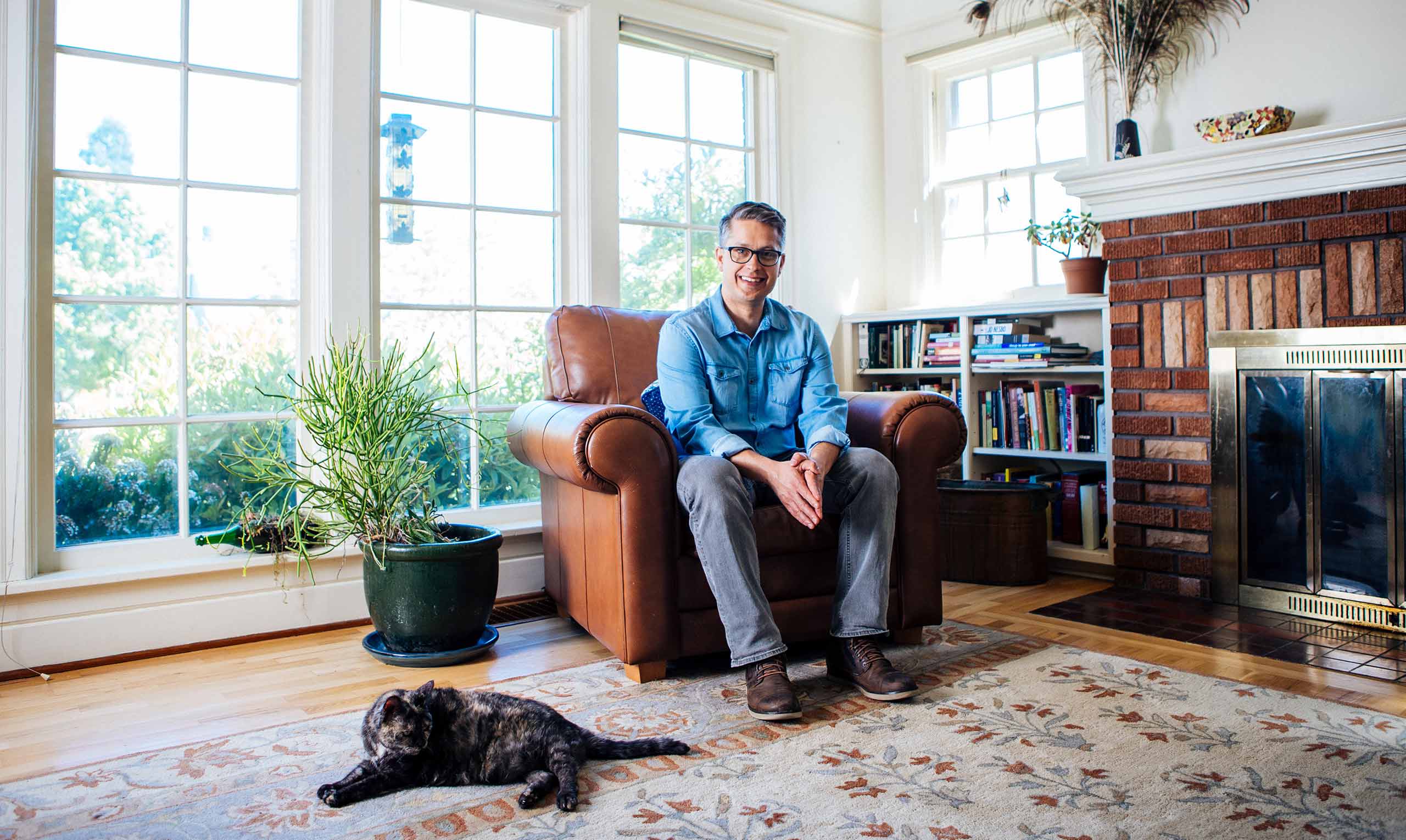 Chris Bone sitting in a comfortable chair in his home